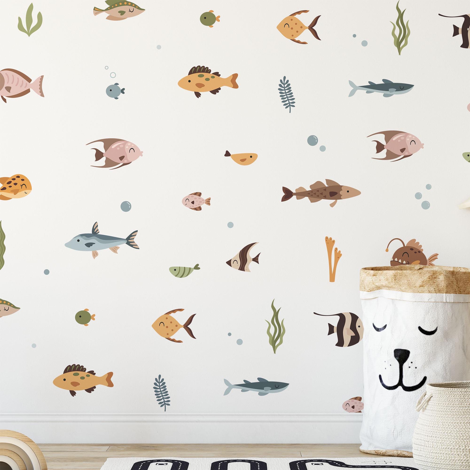 Ocean Fish Stickers by My Store create a playful wall design with colorful cartoon fish and sea creatures on a light background. Whimsical decals enhance the look alongside a smiling animal-faced basket, while marine plants and bubbles complete the enchanting ocean life theme.