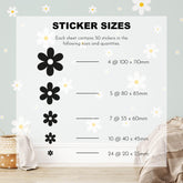 A delightful chart features My Stores Daisy Wall Decals as removable floral stickers, elegantly displaying sizes on a nursery wall: 4 at 100x110mm, 5 at 80x85mm. The setup is enhanced with a woven basket and blanket nearby.