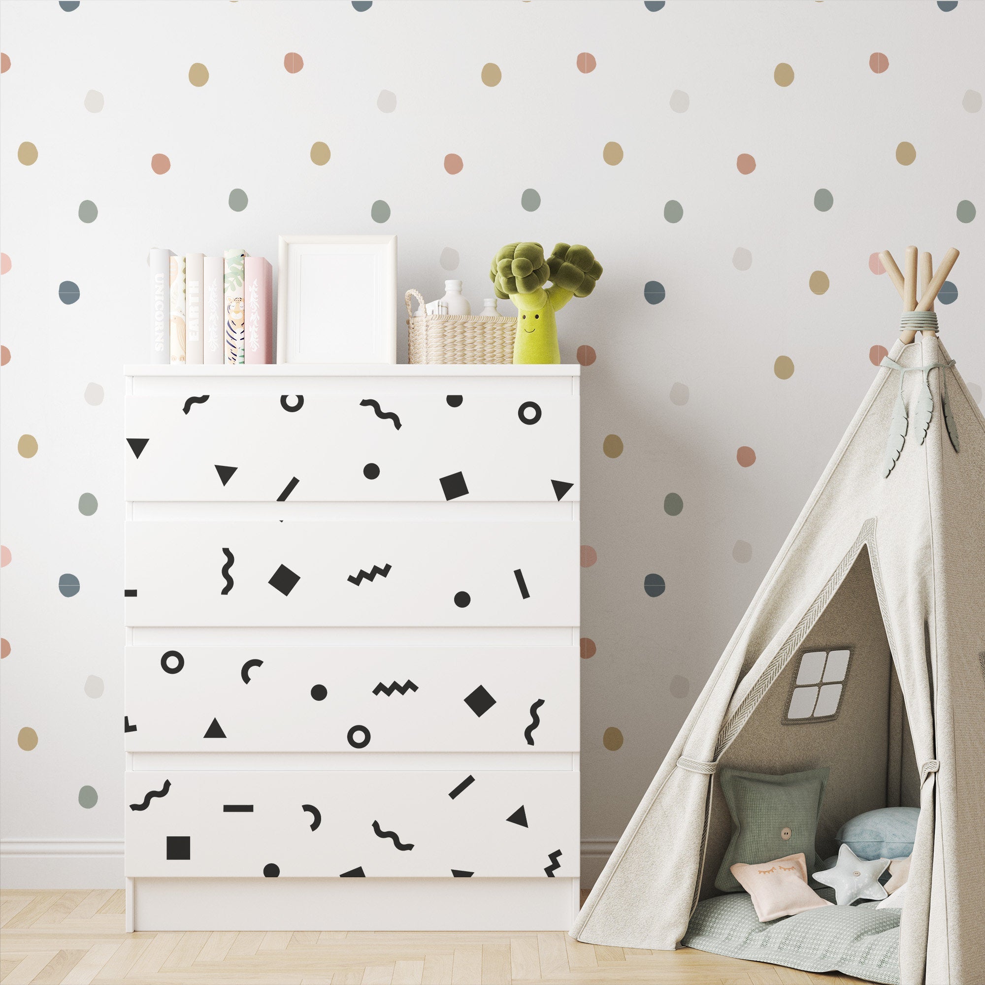 A childrens room includes a white dresser with geometric patterns, a stack of books, and a green toy on top. The wall showcases My Stores Retro Doodle Stickers, while a cozy teepee tent with cushions is arranged on the right.
