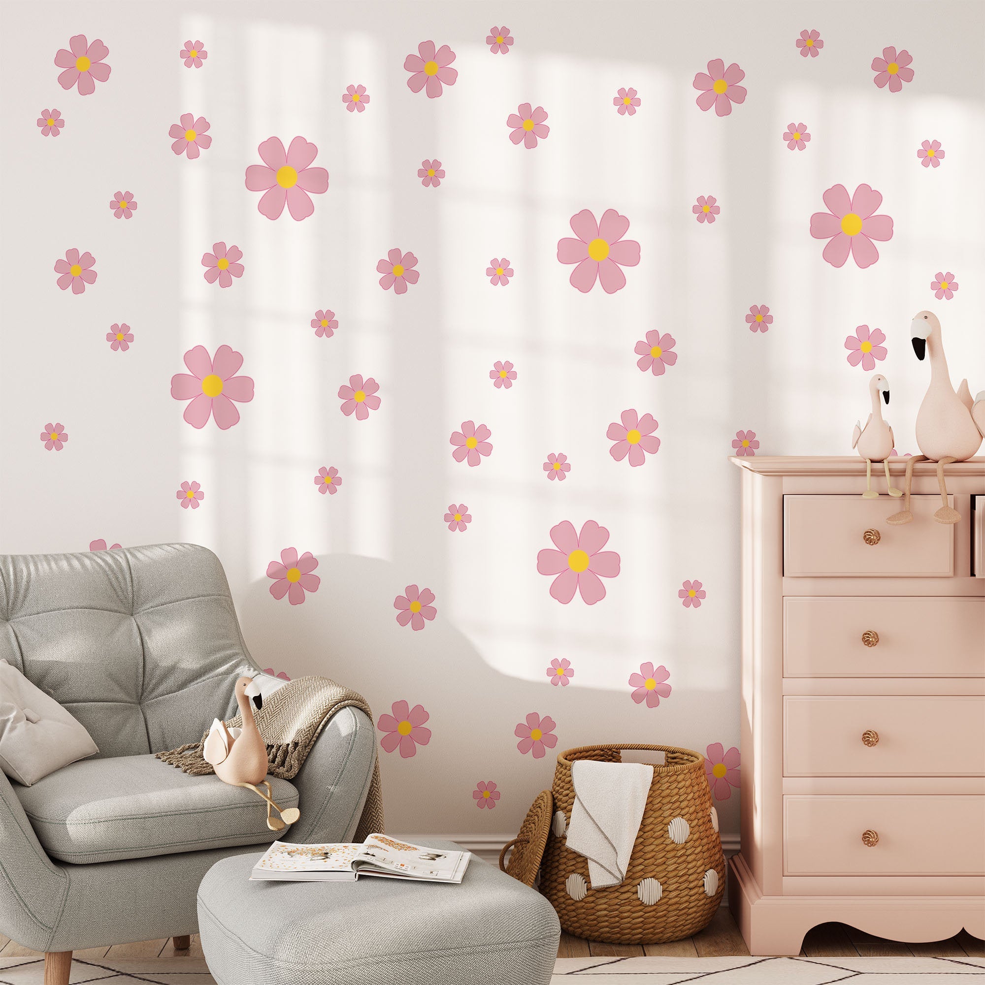 A cozy room includes a light armchair with a plush toy, a pink dresser, and a basket. The wall is adorned with My Stores Pink Daisy Stickers, adding a playful touch to the space.