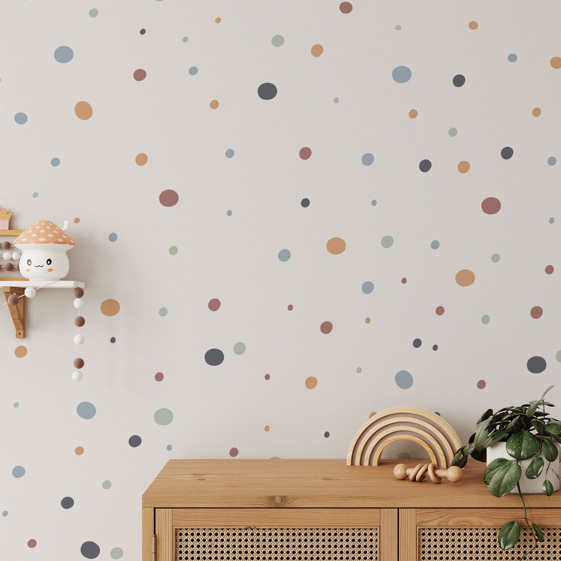 The room features beige walls adorned with My Stores Boho Polka Dots Stickers in various colors. A wooden cabinet displays a rainbow-shaped toy and plant, while a small shelf showcases a mushroom toy and a plush toy with hanging beads.